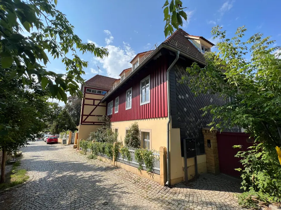 Das Wohnhaus von der Gasse aus: Fachwerkgiebel, ochsenblutrote Holzfassade und Schieferwand